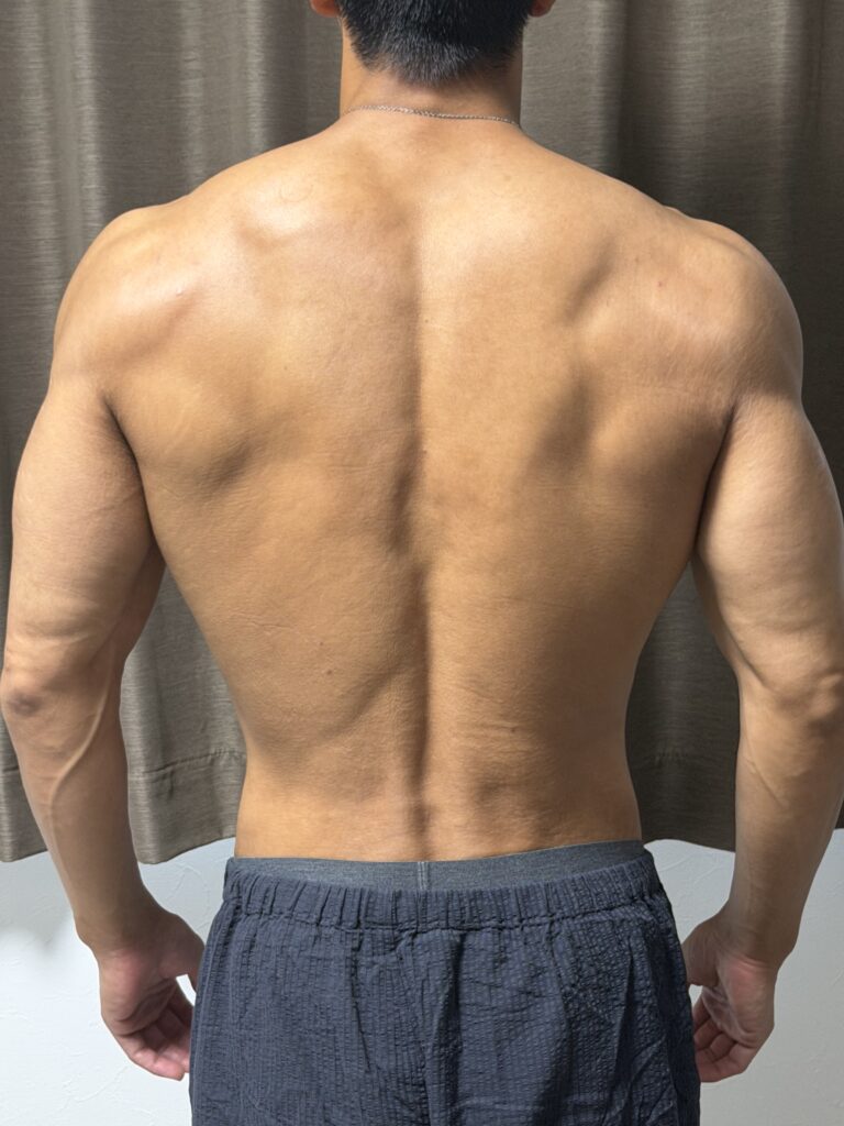 減量28週目の背面写真。体重67.7kg、体脂肪率4.5％で、広背筋の輪郭や肩まわりの立体感、背中の細かいラインが見える状態